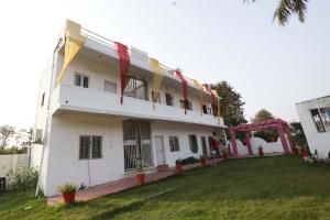 a large white building with a lawn in front of it at OYO Hotel Shahnai Garden in Bhopal
