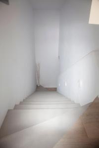 a staircase in an empty room with white walls at Paros Melodia Apartments in Logaras