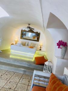 a bedroom with a bed and a mirror in a room at Palm Tree Hill in Oia