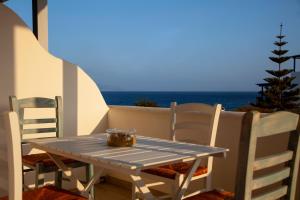 einen Tisch und Stühle auf einem Balkon mit Meerblick in der Unterkunft Paros Melodia Apartments in Logaras