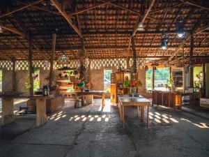 Habitación grande con mesas de madera en un edificio en Pousada Pantanal Experiência, en Miranda