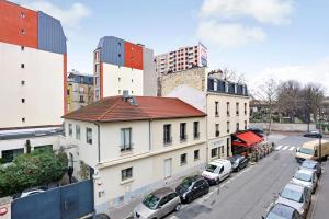 a city street with cars parked in front of a building at Appartement Suite aux Portes de Paris in Clichy