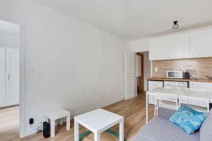 a living room with a table and a kitchen at Appartement Suite aux Portes de Paris in Clichy