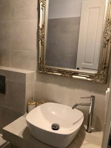 a white sink in a bathroom with a mirror at Barbara΄s Apartments in Argostoli +29 photos
