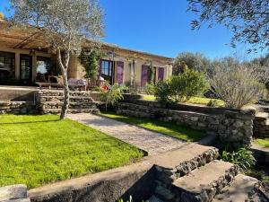 a house with a stone wall and a yard at bastide Uzes à pied Piscine vue imprenable Havre de paix in Uzès