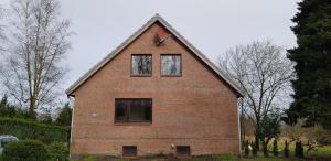 a large brick house with three windows on it at Vogels Ferienhaus in Kreideseenähe in Hemmoor
