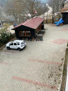 una macchina bianca parcheggiata di fronte a una casa di abantgüneşpansiyon a Bolu