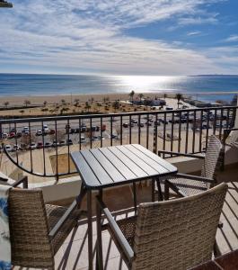 una mesa y sillas en un balcón con playa en Ampuries Delta Apartment, en Empuriabrava