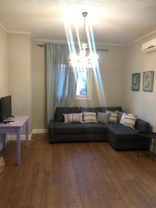 a living room with a couch and a chandelier at Barbara΄s Apartments in Argostoli