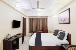 een hotelkamer met een bed en een televisie bij Jupiter Gold Delhi Airport in New Delhi