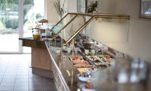 ein Buffet in einem Restaurant mit Tellern voller Essen in der Unterkunft Hotel am Park - Krefeld - Düsseldorf - kühle Zimmer in Willich