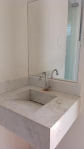 een badkamer met een marmeren wastafel en een spiegel bij Recanto beira mar/pousada Bela vista in Valença