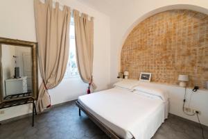 ein Schlafzimmer mit einem Bett und einer Ziegelwand in der Unterkunft Hotel Miramare in Spotorno