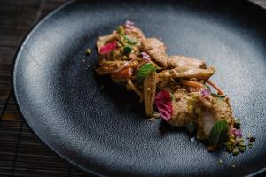 a black plate of food on a table at Lindos Imperial Resort & Spa in Kiotari