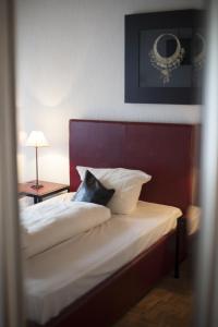 Schlafzimmer mit einem Bett mit rotem Kopfteil in der Unterkunft Hotel am Park in Willich