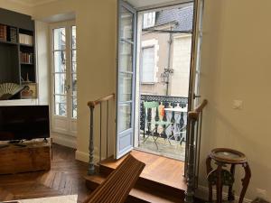 uma sala de estar com uma grande janela e uma televisão em Le Saint Nicolas~Hyper centre em Blois