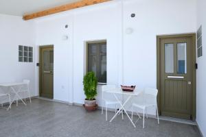 a patio with two doors and a table and chairs at Tressos Maisons in Kimolos