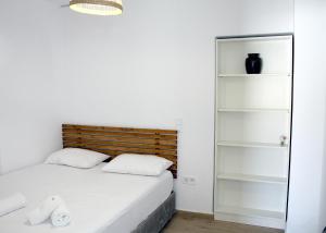 a small bedroom with a bed and shelves at Tressos Maisons in Kimolos