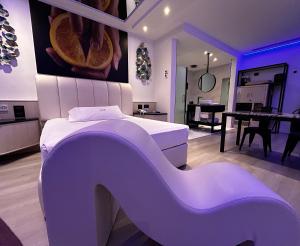 Habitación púrpura con cama blanca y mesa en Zouk Hotel, en Alcalá de Henares