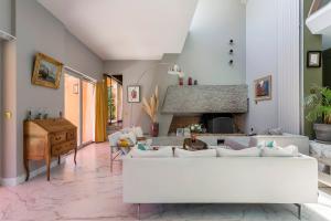 Villa - La champenoise - Hamac Suites في Saint-Didier-au-Mont-dʼOr: غرفة معيشة مع أريكة بيضاء ومدفأة