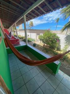 a hammock on the porch of a house at Pousada Brisa do Mar in Galinhos