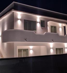 Un bâtiment blanc avec des lumières au-dessus dans l'établissement Villa Clemente, à Marina di Lizzano