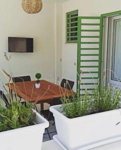 une salle à manger avec une table et deux plantes en pot dans l'établissement Villa Clemente, à Marina di Lizzano