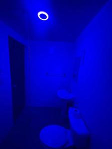 a blue bathroom with two toilets and a light at Mar azul 401 in San Felipe de Puerto Plata