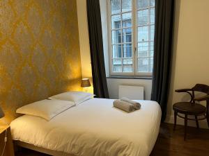um quarto com uma cama branca e uma janela em Le Saint Nicolas~Hyper centre em Blois