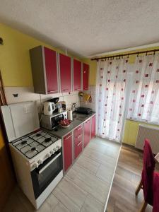 a kitchen with red cabinets and a stove at Studio Apartman Josip in Gospić