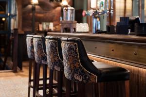 a row of bar chairs sitting at a bar at The Ullswater Inn- The Inn Collection Group in Glenridding