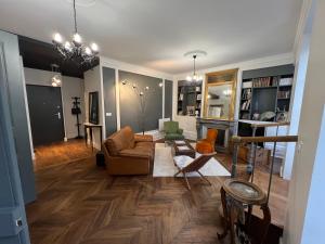 uma sala de estar com um sofá e cadeiras em Le Saint Nicolas~Hyper centre em Blois
