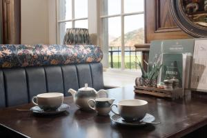 a table with two cups and a tea set on it at The Ullswater Inn- The Inn Collection Group in Glenridding