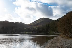 a body of water with mountains in the background at The Ullswater Inn- The Inn Collection Group in Glenridding