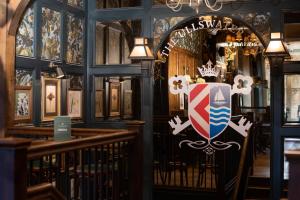 an entrance to a restaurant with a shield on the door at The Ullswater Inn- The Inn Collection Group in Glenridding
