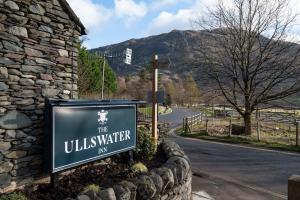 a sign for the ullswater inn on a road at The Ullswater Inn- The Inn Collection Group in Glenridding