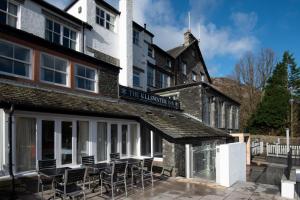 a building with chairs and tables in front of it at The Ullswater Inn- The Inn Collection Group in Glenridding
