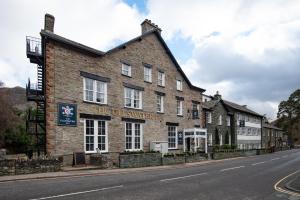 a large brick building on the side of a street at The Ullswater Inn- The Inn Collection Group in Glenridding