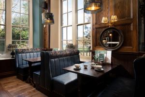 a restaurant with couches and a table and windows at The Ullswater Inn- The Inn Collection Group in Glenridding
