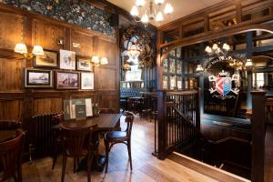 a restaurant with wooden walls and tables and chairs at The Ullswater Inn- The Inn Collection Group in Glenridding