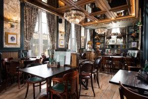 a restaurant with tables and chairs and windows at The Ullswater Inn- The Inn Collection Group in Glenridding