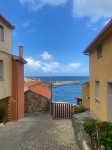 uma vista para o oceano entre dois edifícios em Casa de playa TABI Caión- A Coruña (VUT-CO-000899) em Cayón