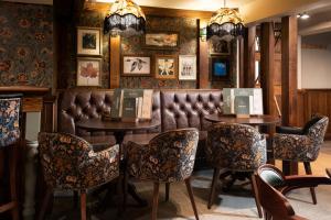a bar with two tables and a leather bench at The Ullswater Inn- The Inn Collection Group in Glenridding