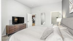 Habitación blanca con cama y TV en Landing Modern Apartment with Amazing Amenities (ID4080X59) en Minnetonka