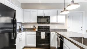 托萊多的住宿－Landing Modern Apartment with Amazing Amenities (ID8147X5)，厨房配有白色橱柜和黑炉。