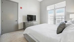 a white bedroom with a bed and a television at Landing Modern Apartment with Amazing Amenities (ID1000X551) in Westlake