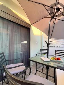Whispering Ocean Retreat في بوليغيروس: طاولة وكراسي مع مظلة في الغرفة