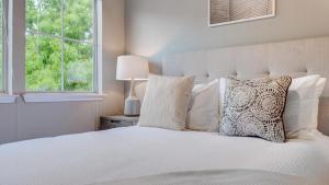 1 dormitorio con cama blanca y ventana en Landing Modern Apartment with Amazing Amenities (ID4600X56) en Irving