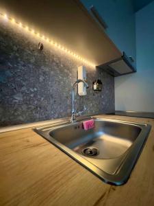 un fregadero de acero inoxidable en una cocina con luces en Whispering Ocean Retreat, en Polígiros