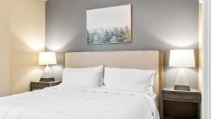 a bedroom with a white bed with two lamps at Landing Modern Apartment with Amazing Amenities (ID7864X05) in Memphis
